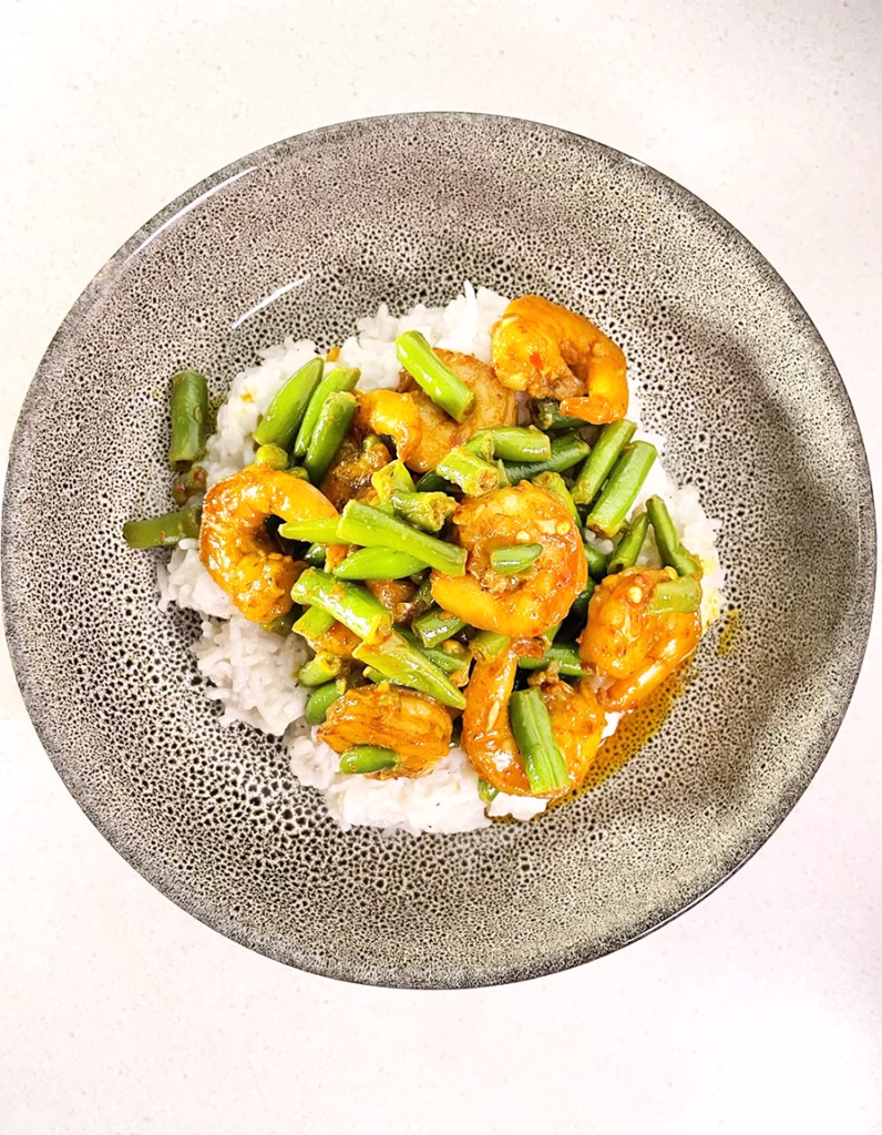 Butter garlic prawn and bean stir fry is served with creamy coconut rice